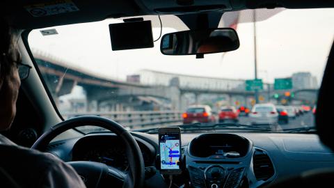 picture of senior driving from backseat perspective with a line of cars ahead on the highway