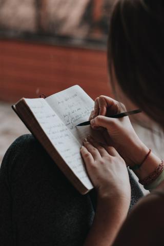 person writing into a journal