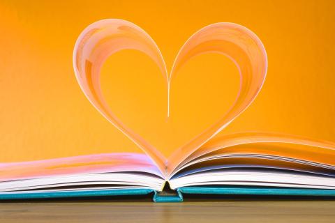 open book image with pages curled into a heart