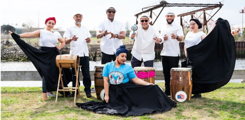 img of movimiento cultural group posing together with drums