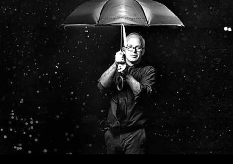 photograph of the artist under an umbrella