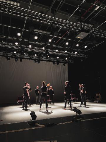 group of actors on stage in a circle